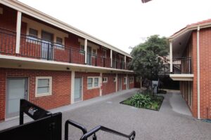 Two long, doube-storey brick buildings, each comprised of multiple joined units