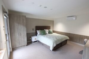 Room with double bed, bedside table and wardrobe